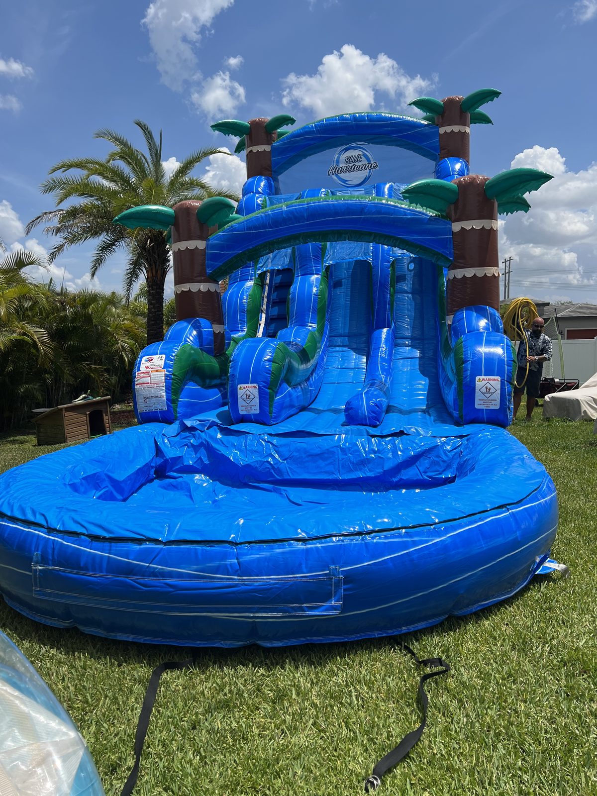 Blue Hurricane double-lane waterslide with splash pool set up in a backyard